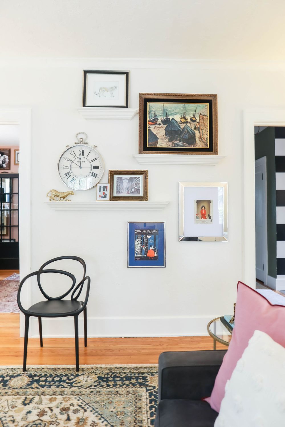 Gallery wall arrangement in living room with modern furniture and vintage-style area rug.