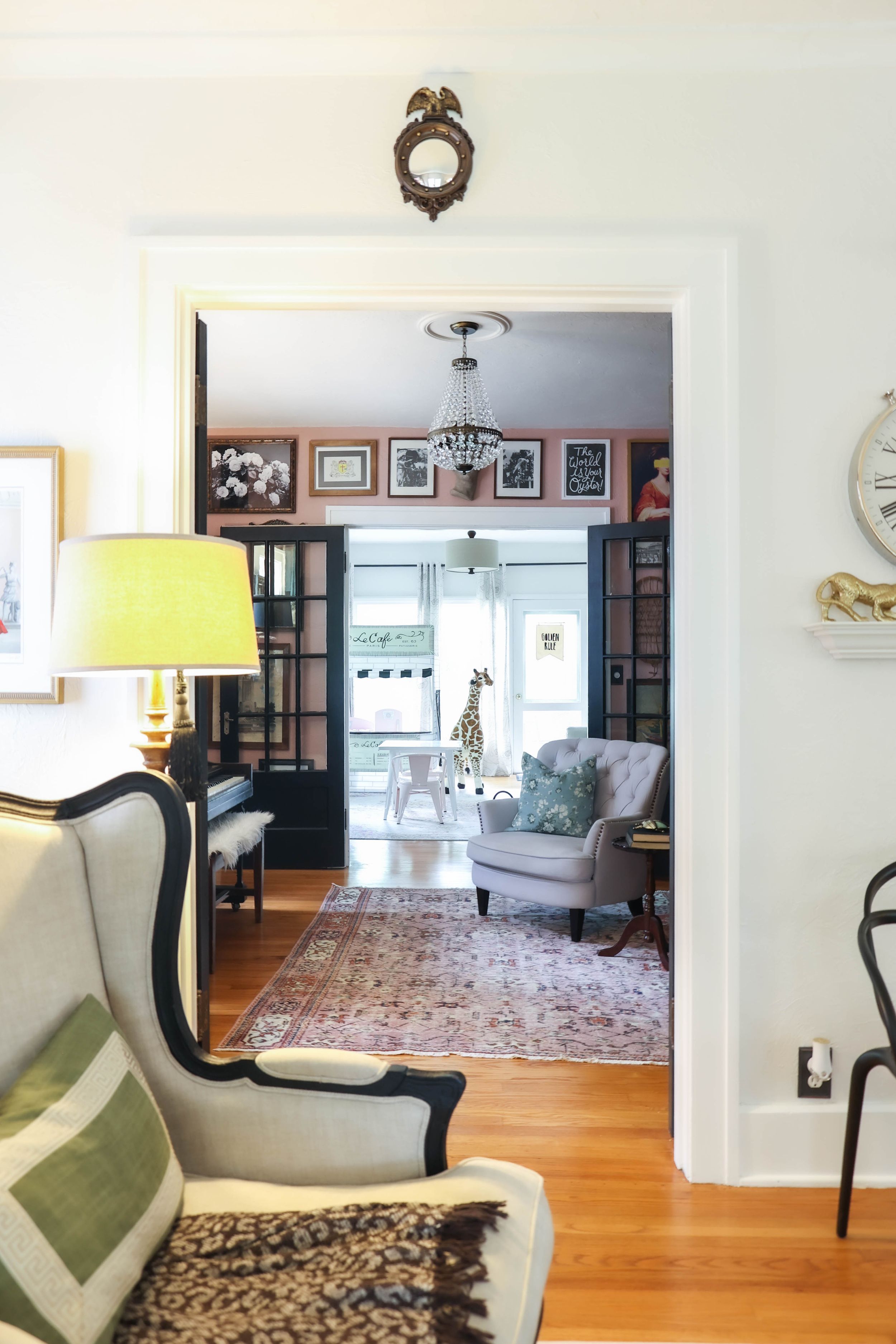 Elegant living room with hardwood floors, ornate area rug, and classic armchair in cream upholstery.