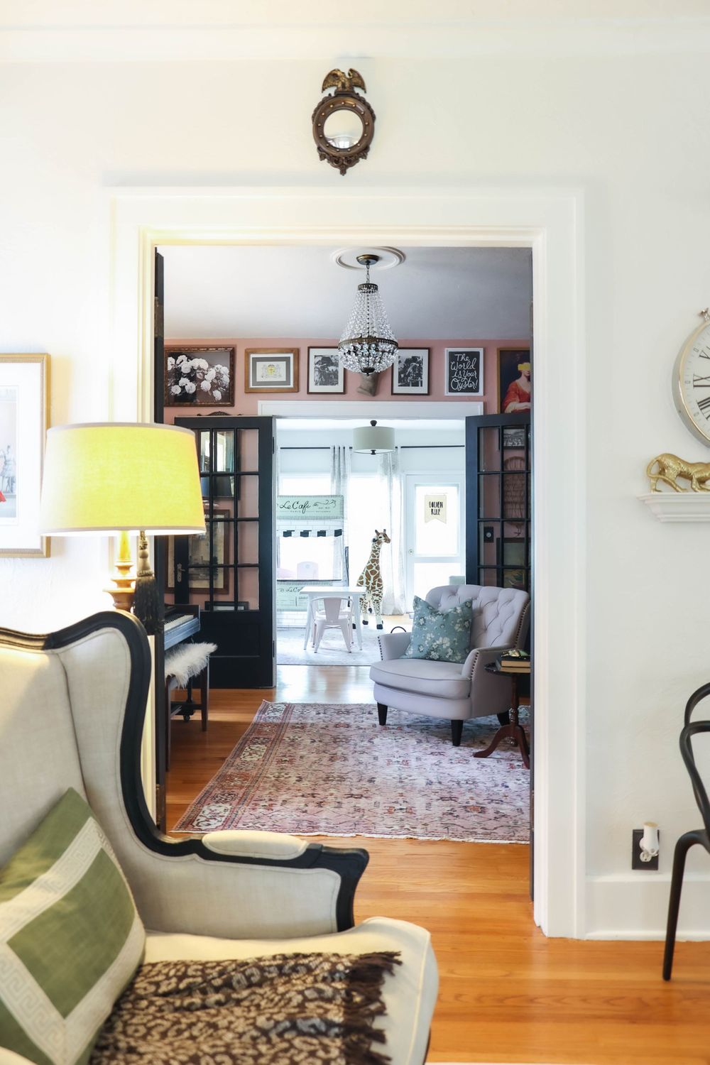Elegant living room with hardwood floors, ornate area rug, and classic armchair in cream upholstery.