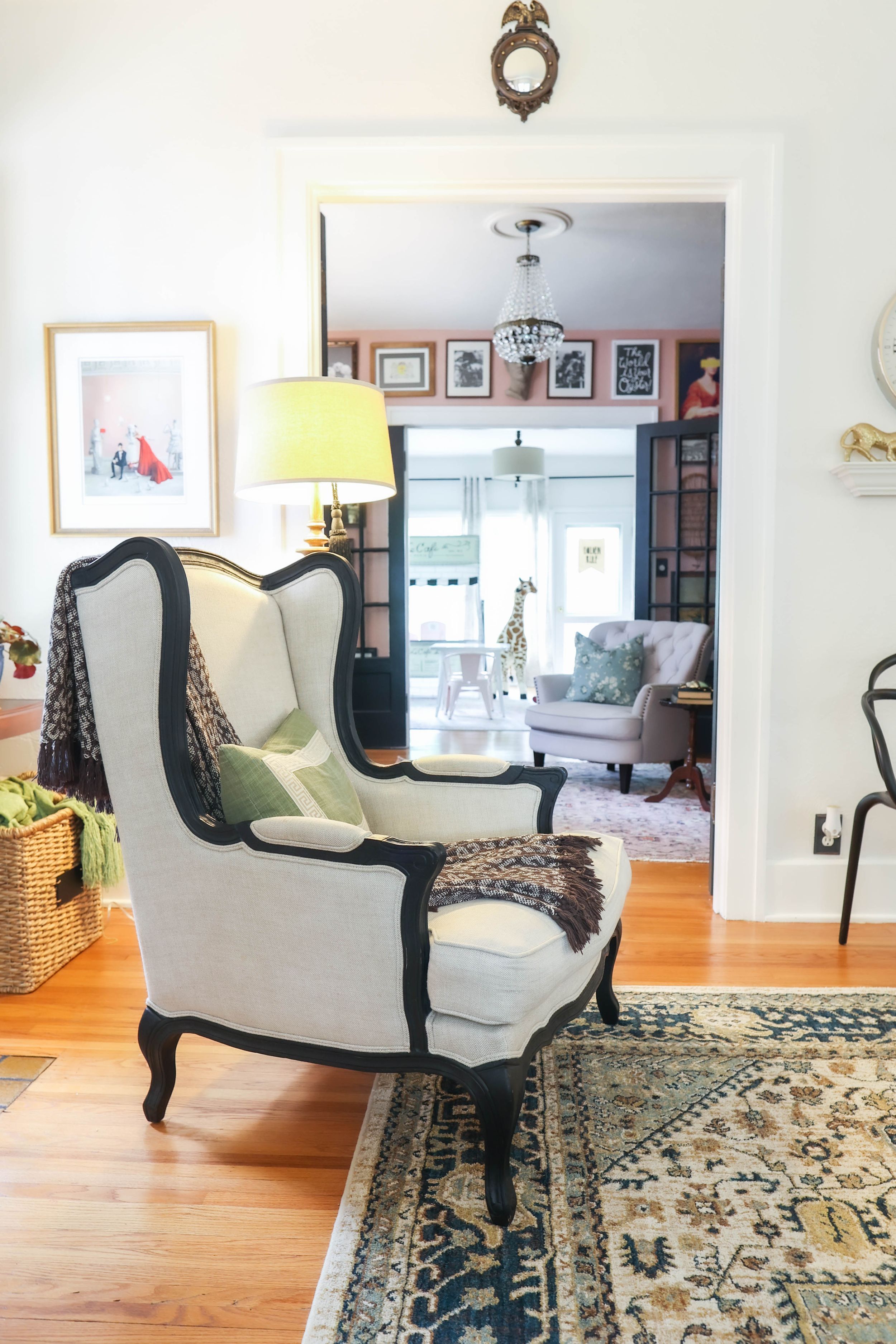 Open concept living space featuring vintage-style chairs and decorative area rug on hardwood flooring.