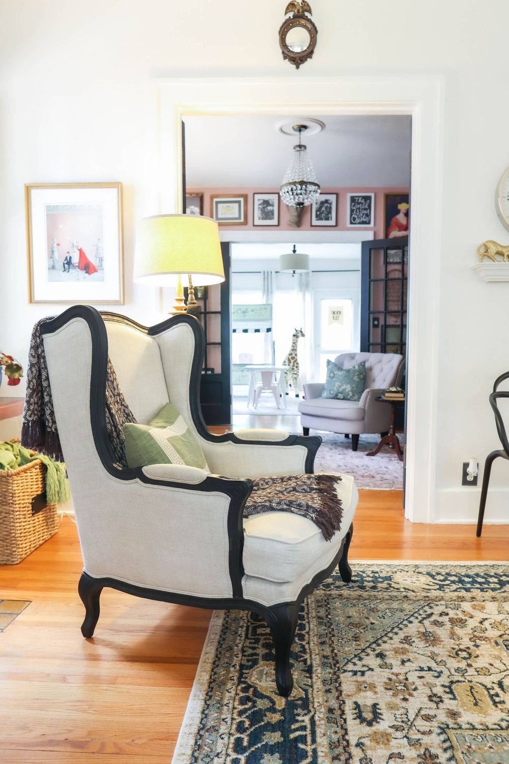 Open concept living space featuring vintage-style chairs and decorative area rug on hardwood flooring.