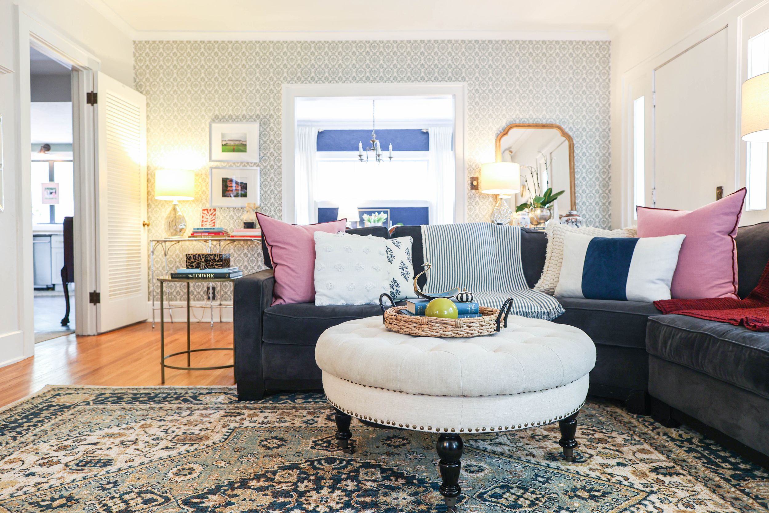 Spacious living area with contemporary furniture and patterned area rug in neutral tones.
