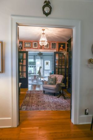 Elegant living room with hardwood floors and built-in bookshelves features a vintage-style area rug.