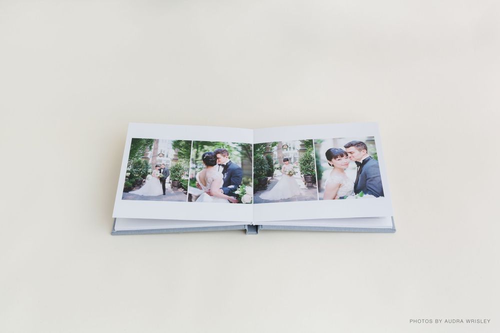 Open wedding album displaying multiple professional photographs on white pages.