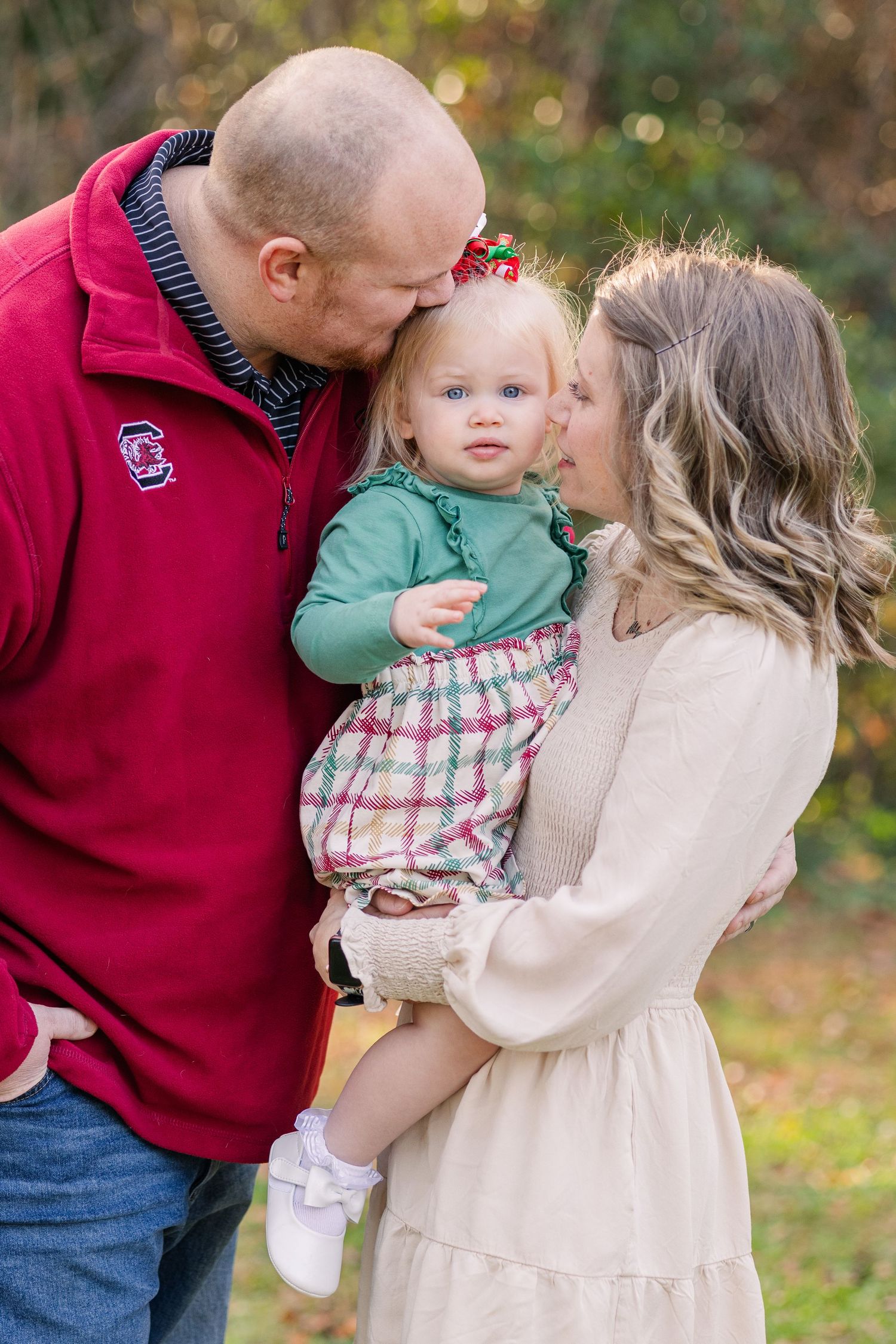 A family shares an intimate moment together outdoors during a fall photoshoot.