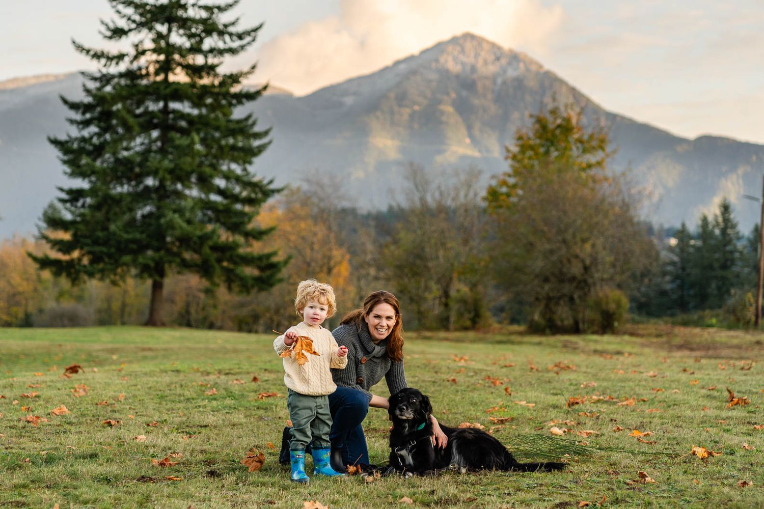 Family portrait with their dog and a mountain backdrop in Tanner Landing Park.