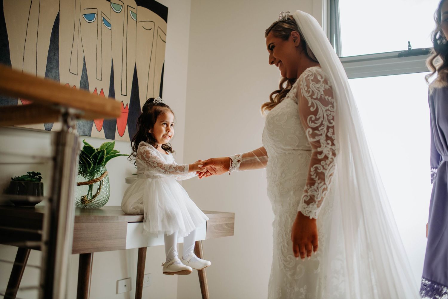 An intimate wedding moment showing interaction between the bride and a young attendant.