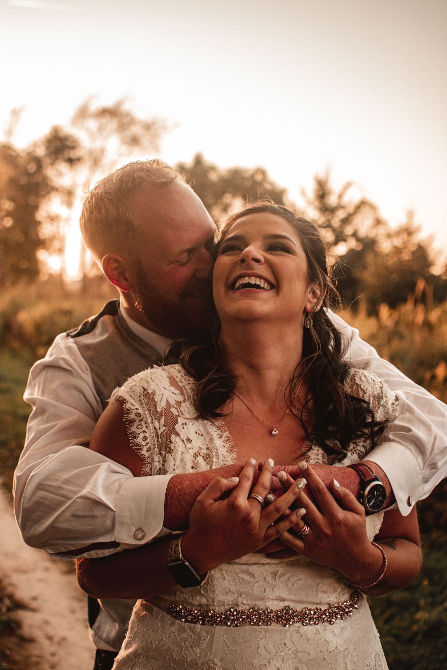 Joyful newlyweds share intimate moment during golden hour portrait session.