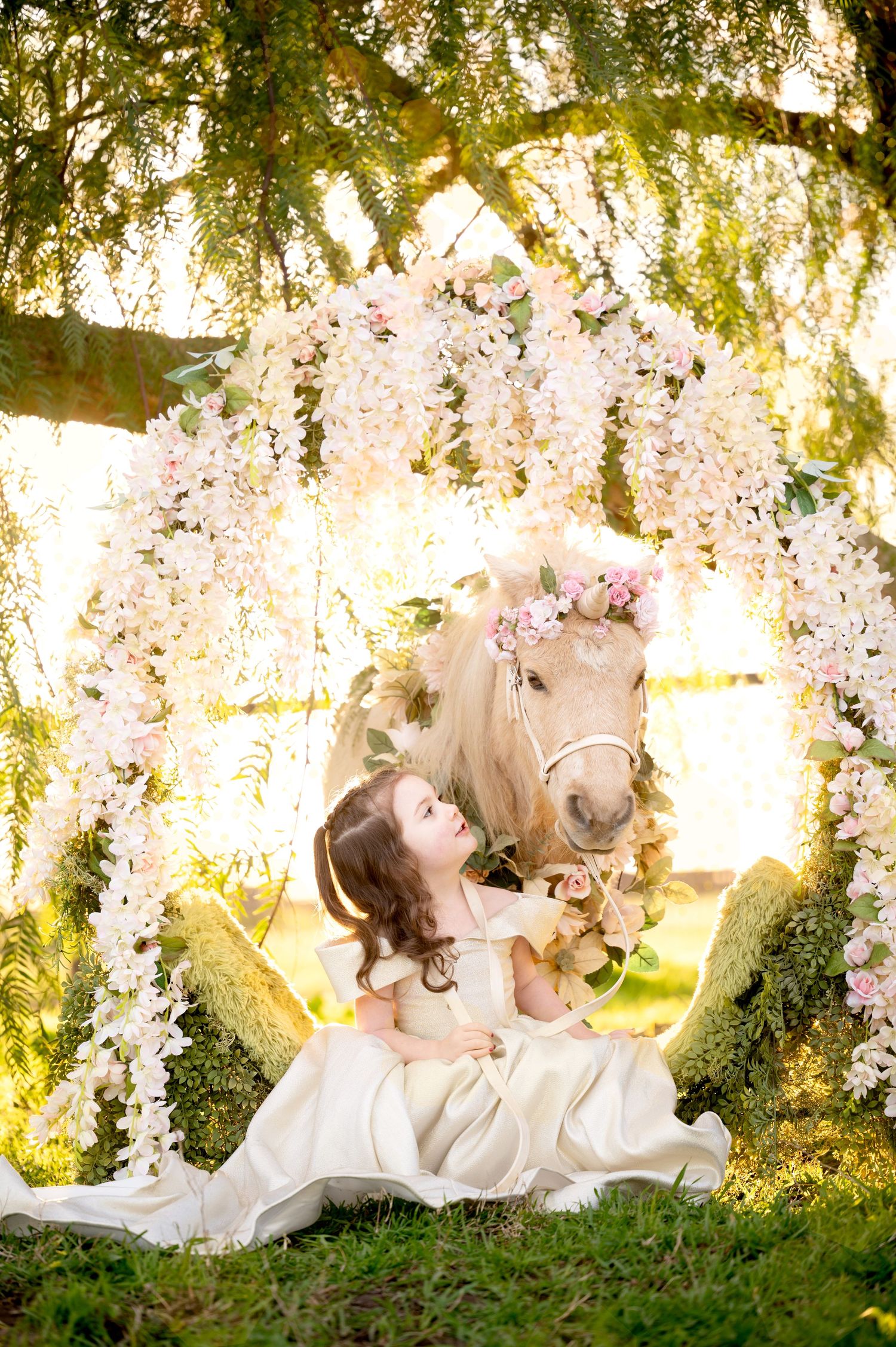 Dreamy garden scene with decorated pony under flowering archway at sunset.