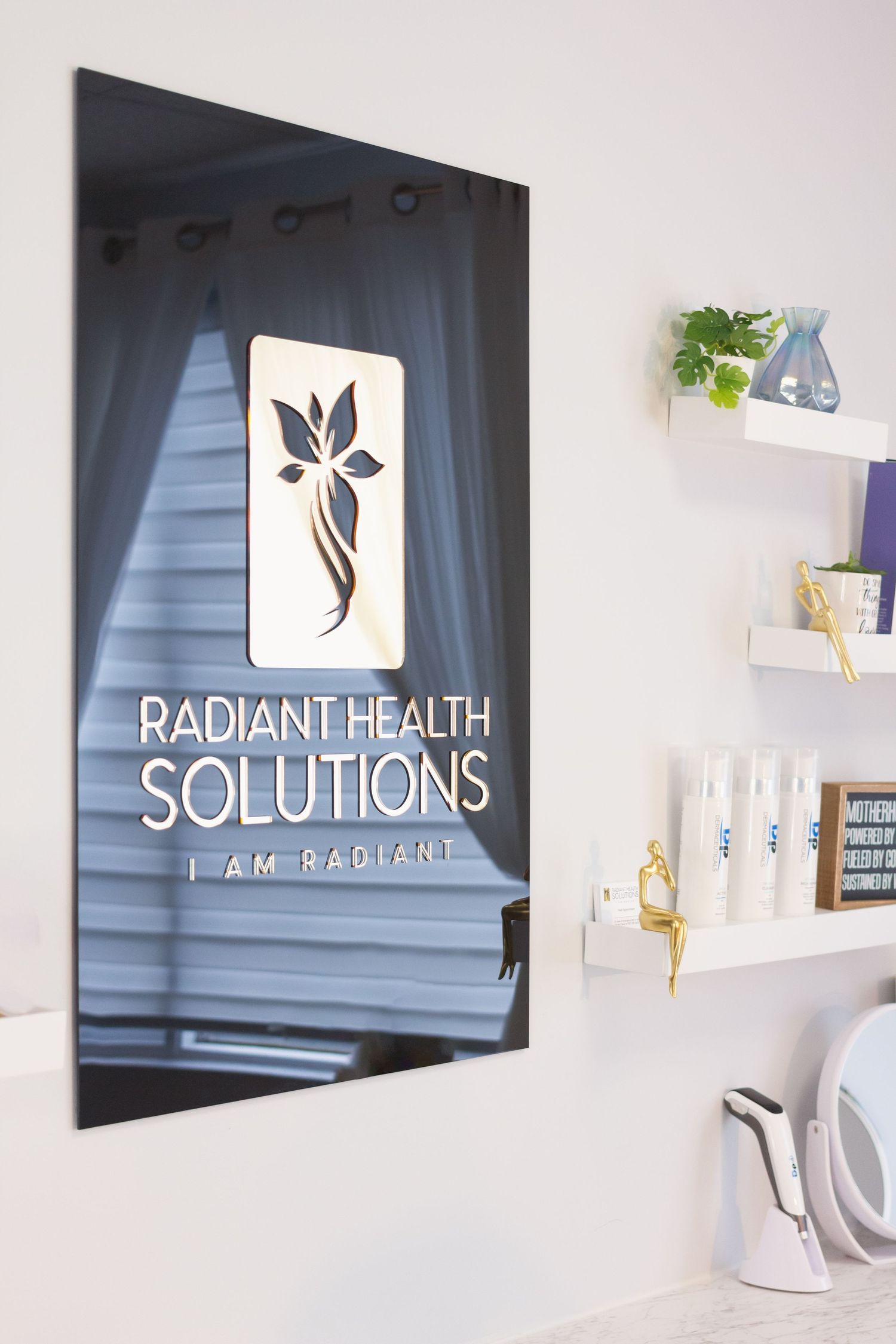 Professional spa logo design for Radiant Health Solutions displayed on a dark wall with white shelving and decor.