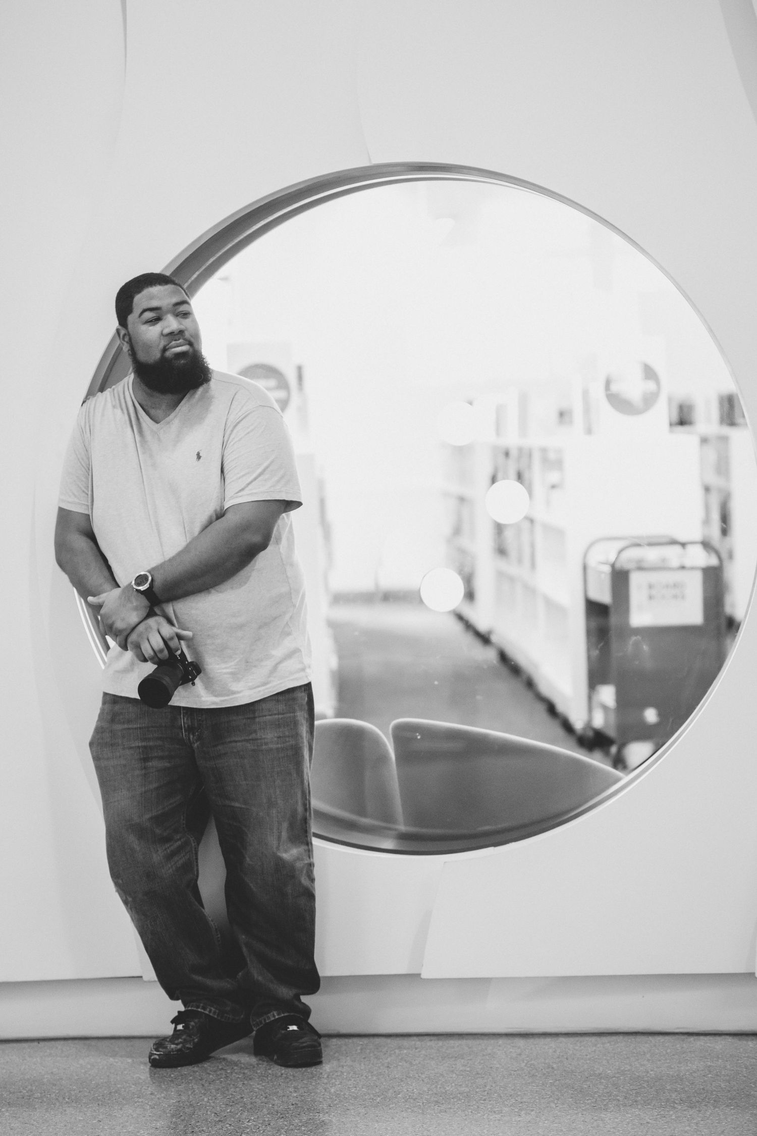 Black and white image of a black male with camera in hand
