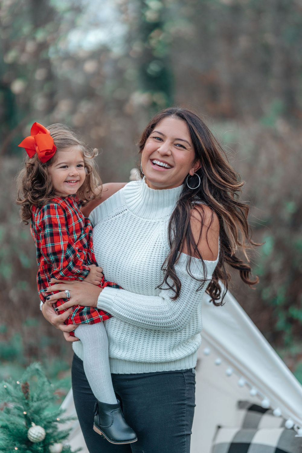 Holiday portrait featuring matching red and white winter outfits against a natural backdrop.