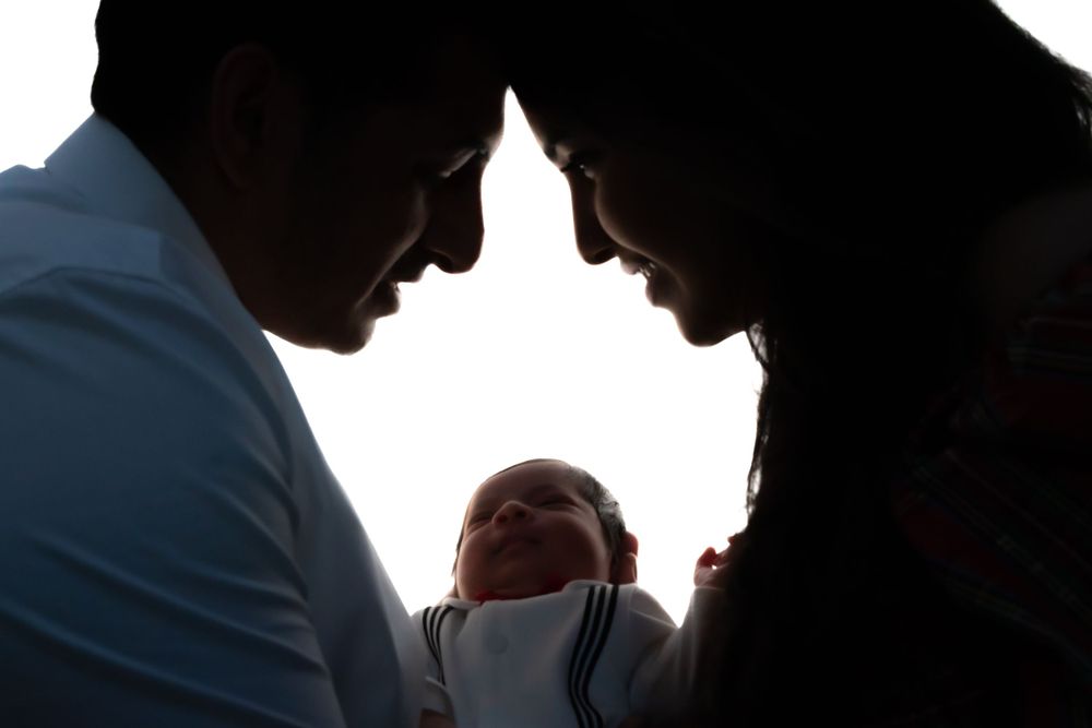 Silhouette of a family sharing an intimate moment with their newborn baby.