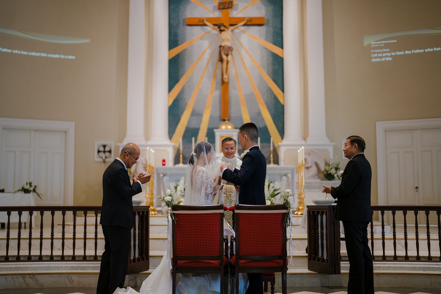 Church altar with crucifix and sunburst design during a wedding ceremony.