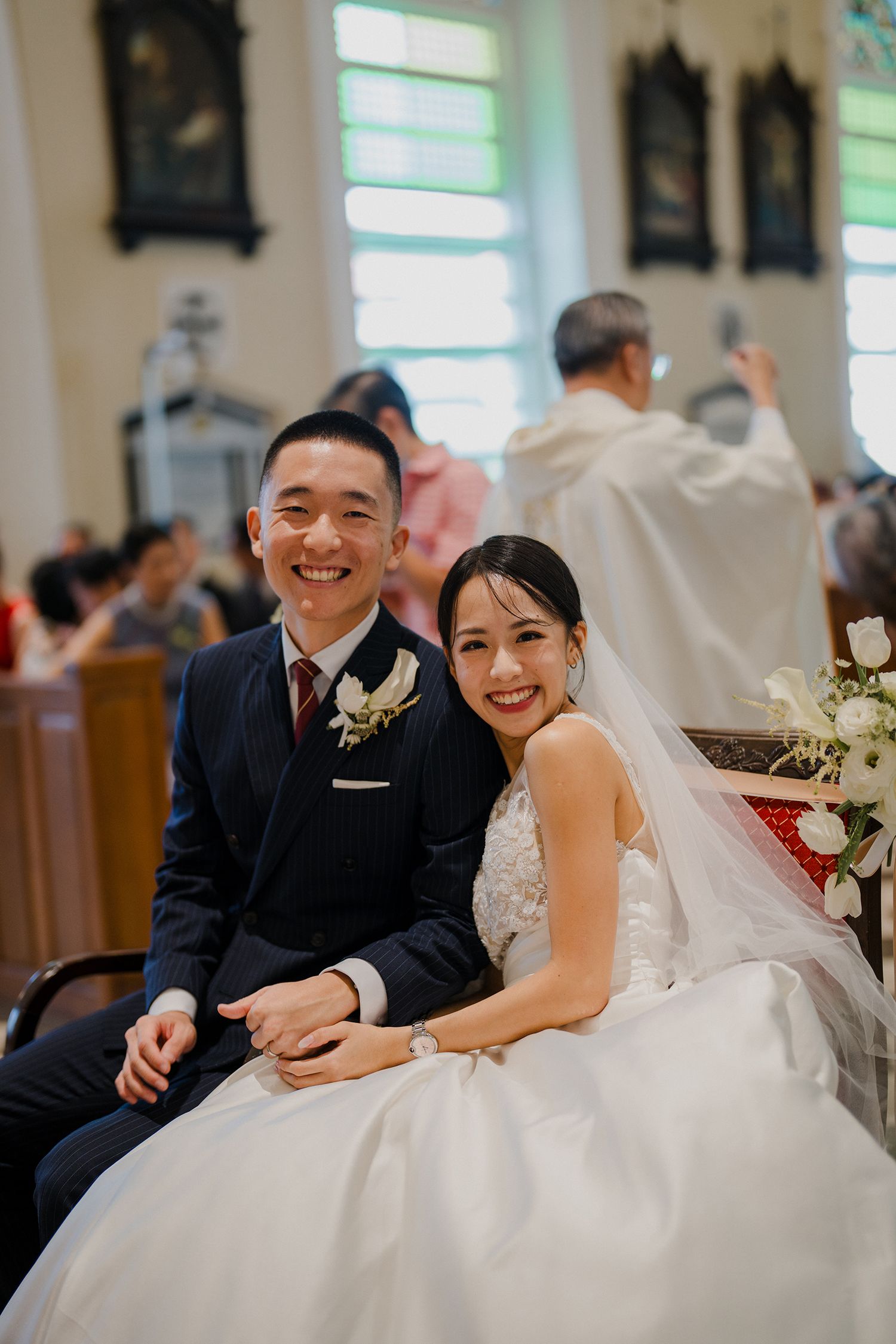 A joyful moment during a wedding ceremony in a church with sunlight streaming through windows.