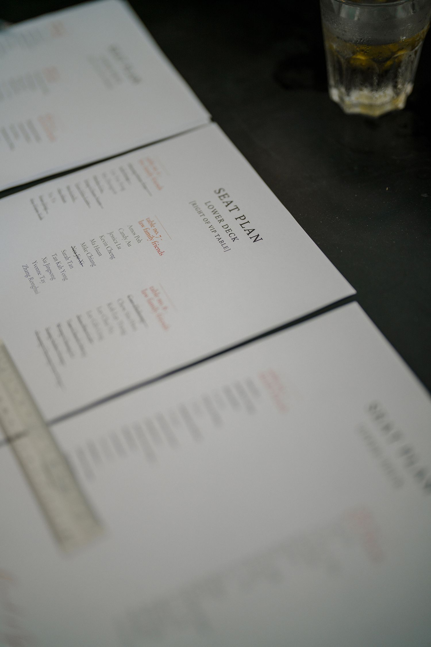 Close-up of wedding menus arranged on a dark table surface.