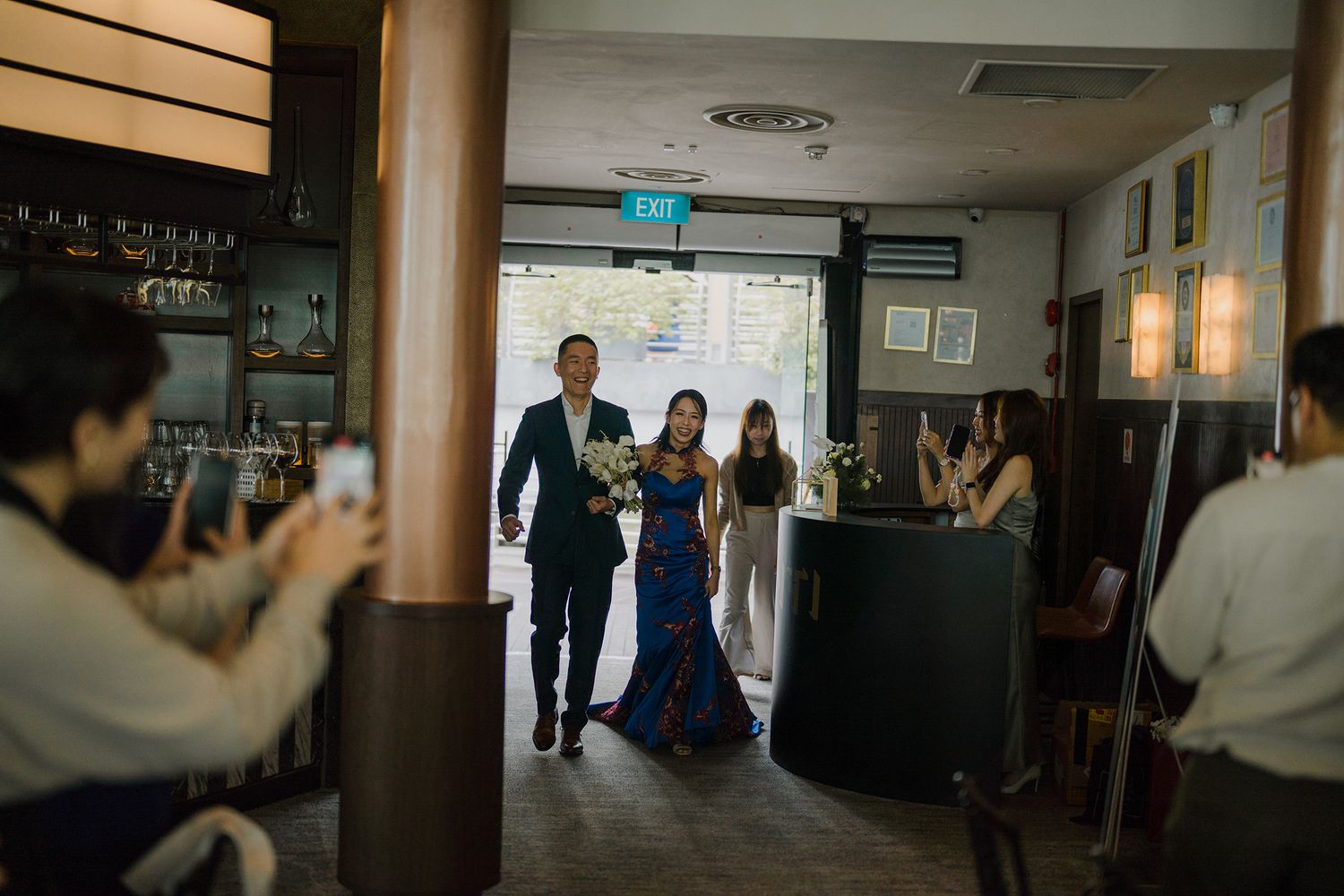 Panoramic view of wedding guests mingling in a reception hallway.