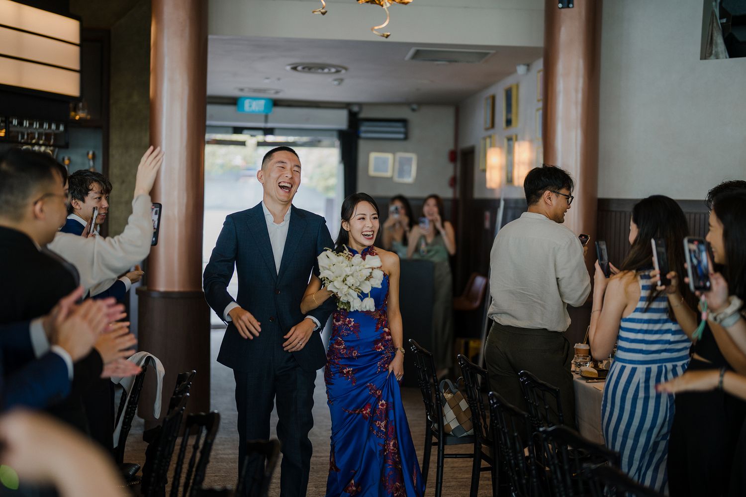 Wedding guests dance and celebrate at an indoor reception venue.