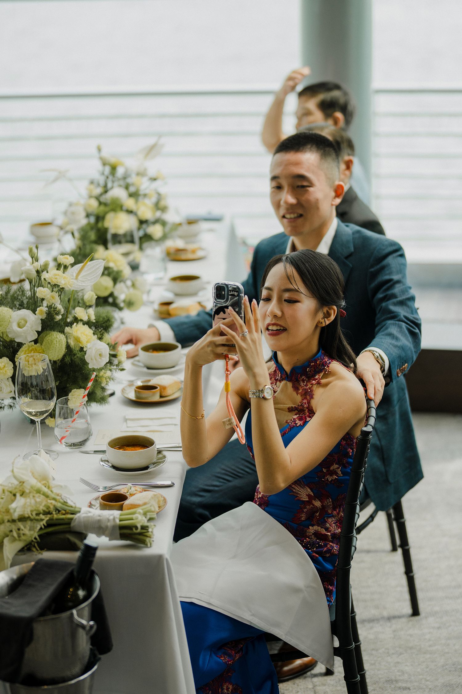 Guests enjoying a celebratory moment at an elegant reception with white floral decor.