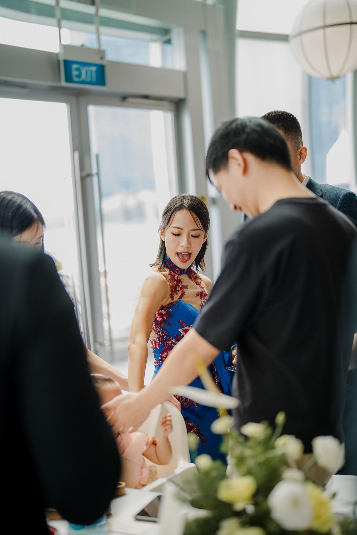 Wedding guests enjoying a formal dining experience with elegant table settings and natural lighting.