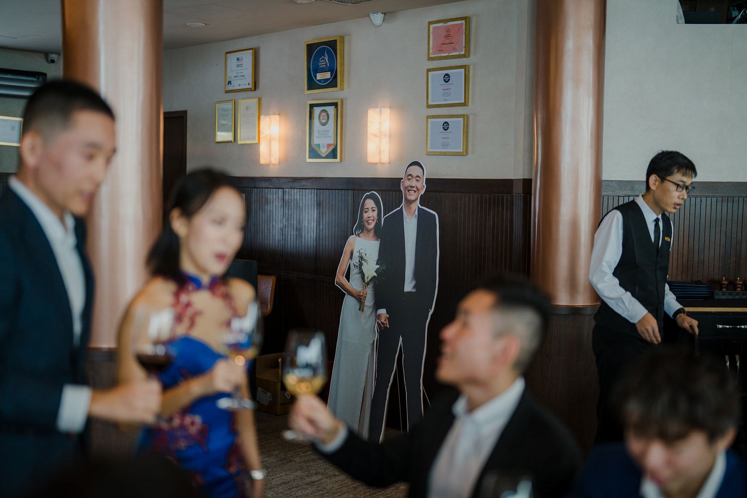 Indoor celebration at an upscale venue with framed artwork on wood-paneled walls.