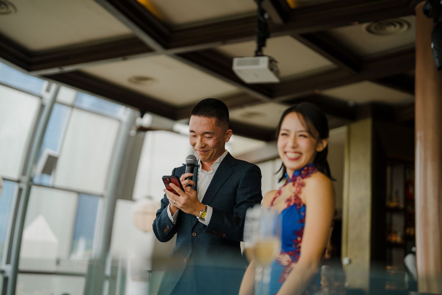 Elegant reception celebration in a modern venue with decorative lighting and city views.