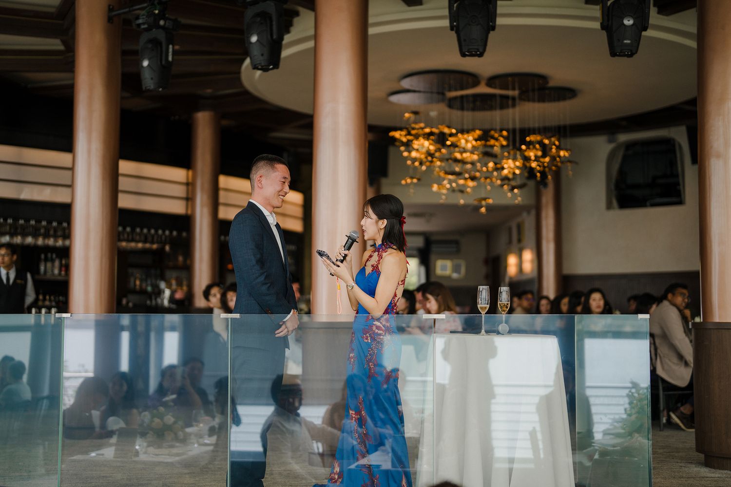 Reception venue decorated with golden lights and glass railings for an elegant celebration.