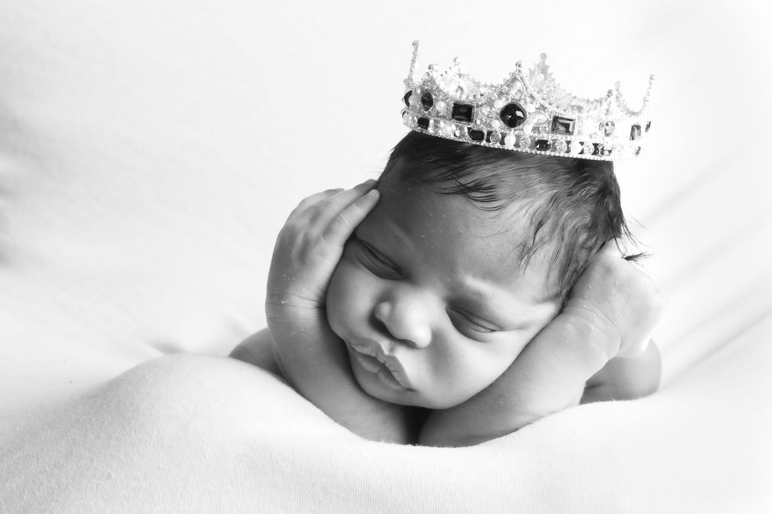 Black and white close-up newborn photography session with soft lighting.