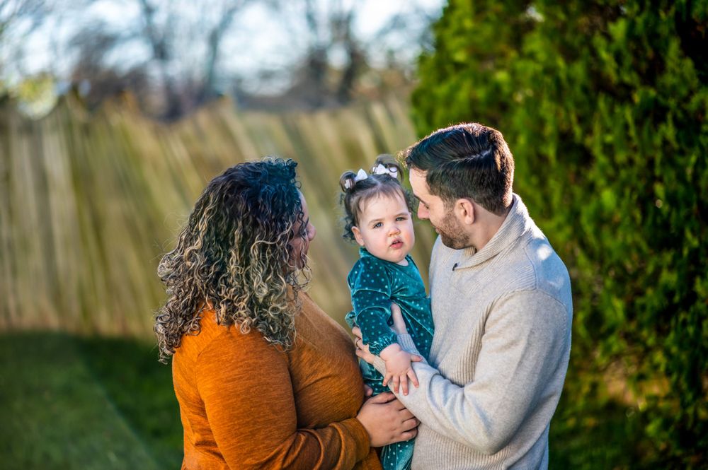 Family sharing joyful outdoor moment together against green garden backdrop.