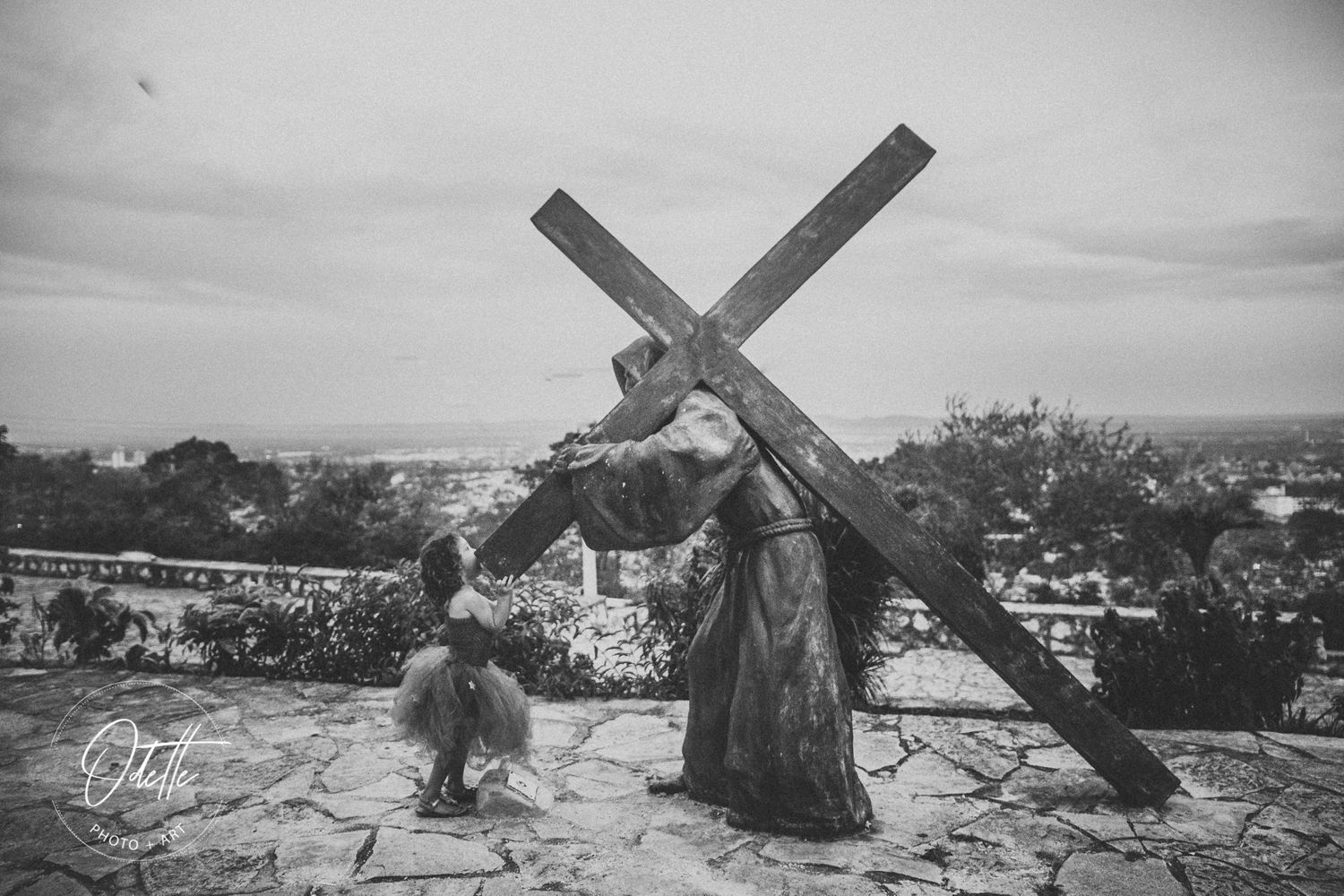 girl helping a statue with the Cross