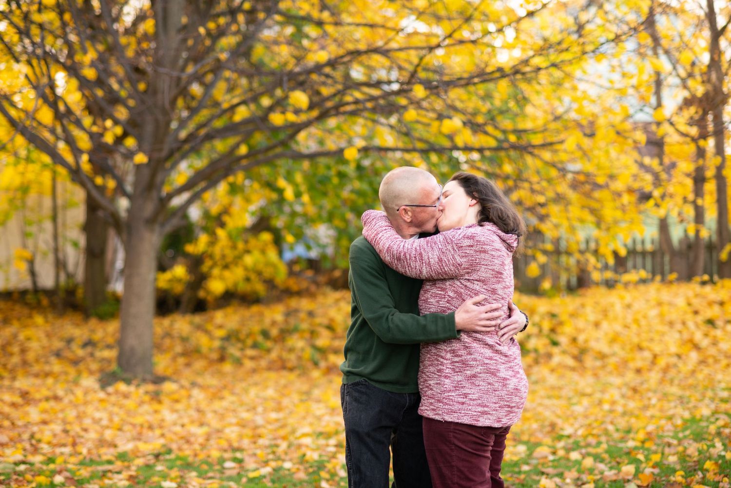 Older couple kiss during engagement portraits with Fall Foliage in Winthrop with Leah Ramuglia Photography