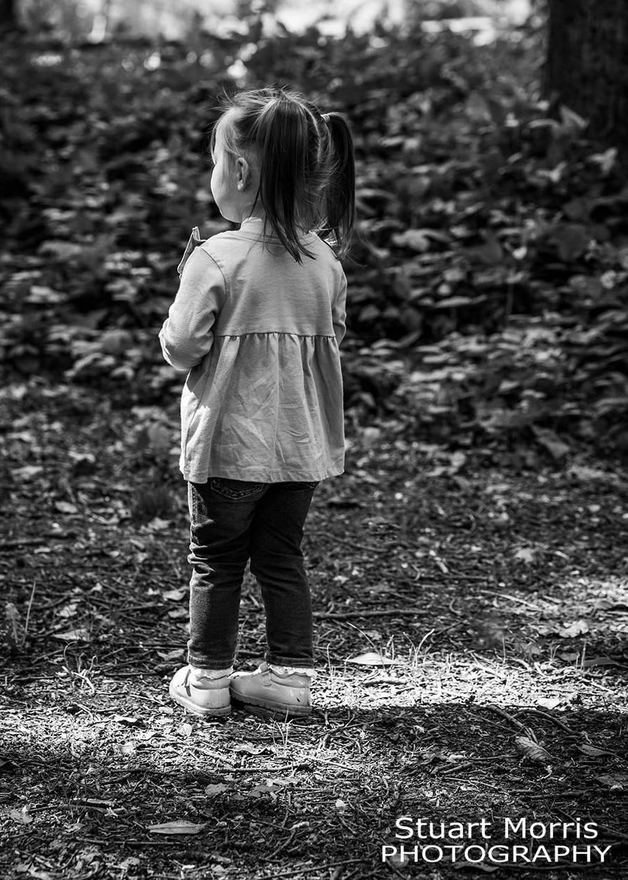 little girl stands in th woods at Walton hall gardens mini outdoor photo session. Stuart Morris Photography