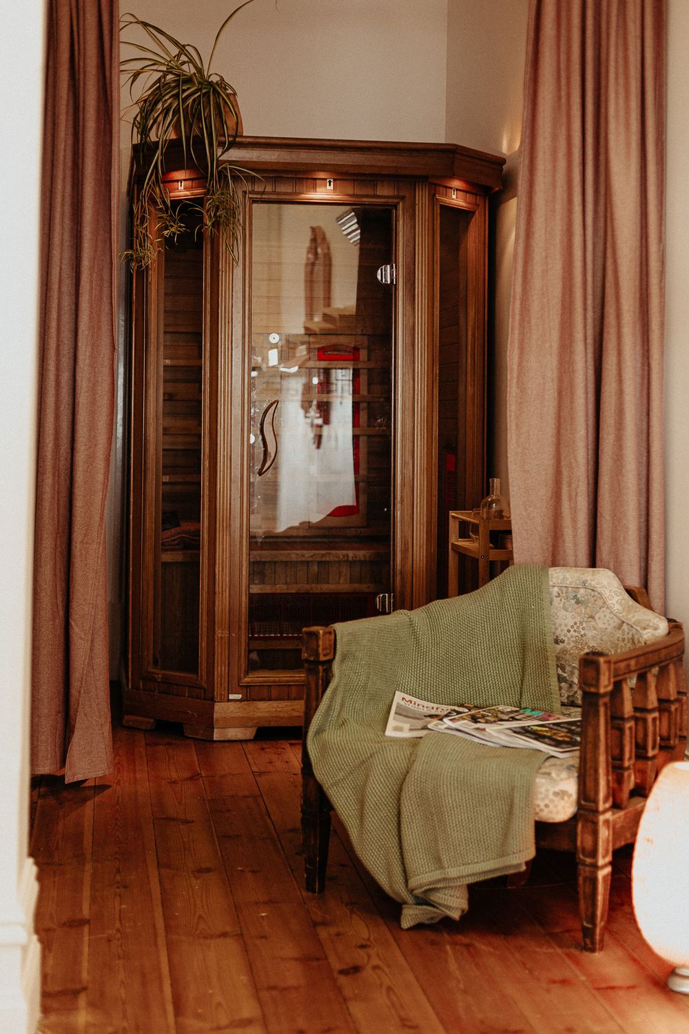 Hallway with wooden floors and green furniture featuring vintage-style pink curtains.
