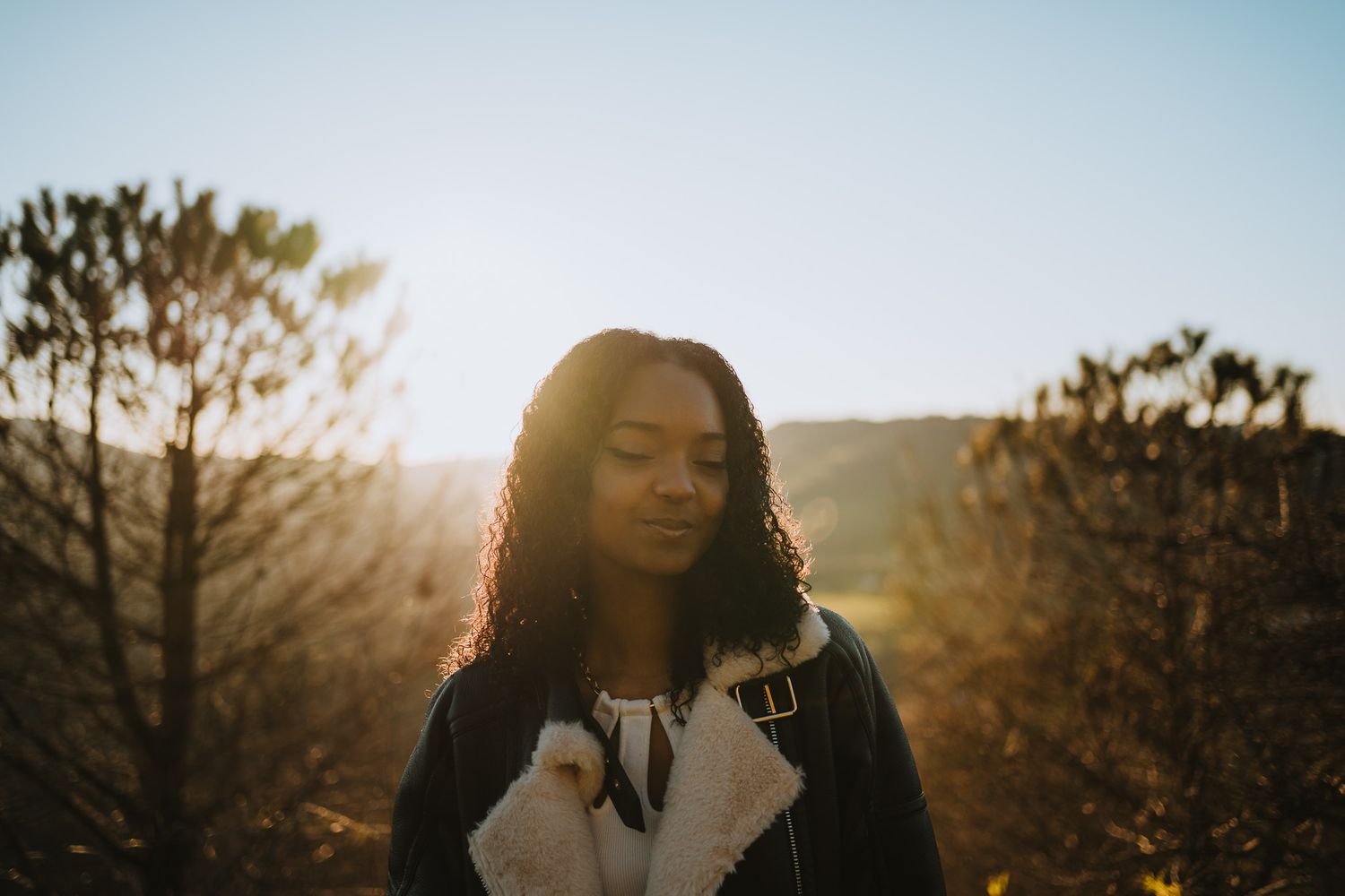 Backlit portrait against golden sunset in natural desert landscape.