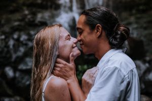 A romantic couple sharing an intimate moment by a waterfall.