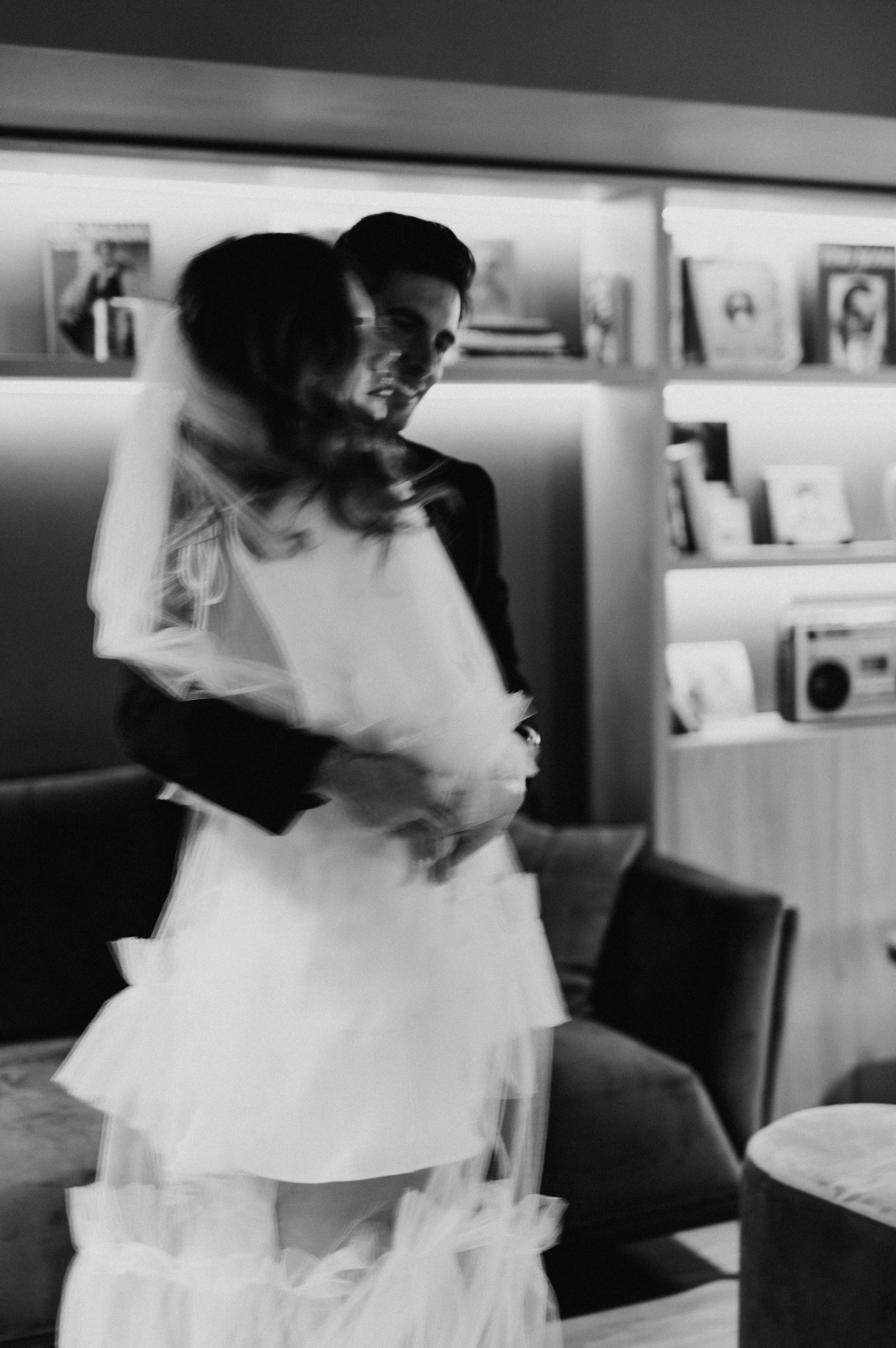 A couple in black and white shares an intimate moment in an indoor setting.