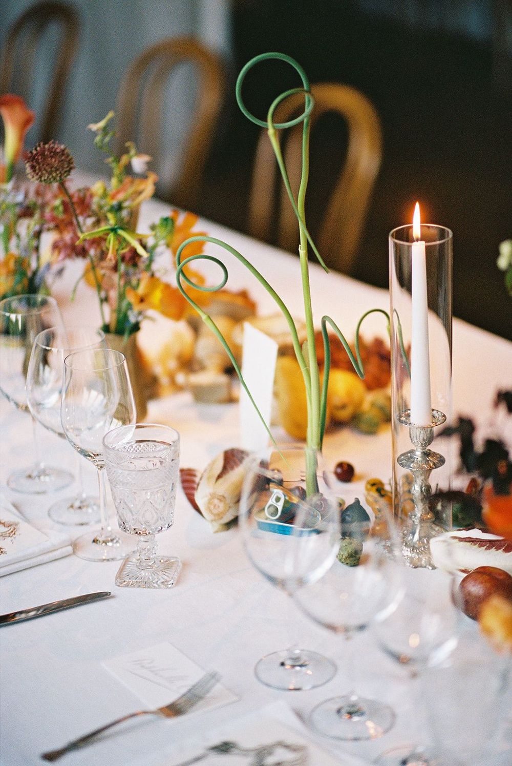 Elegantly set table with colorful floral centerpieces and glassware for a special occasion.