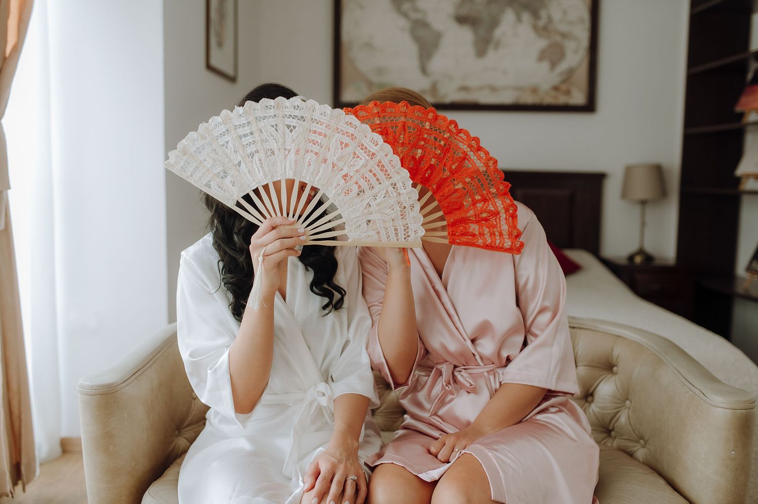 Wedding morning preparations with decorative hand fans in white and coral.
