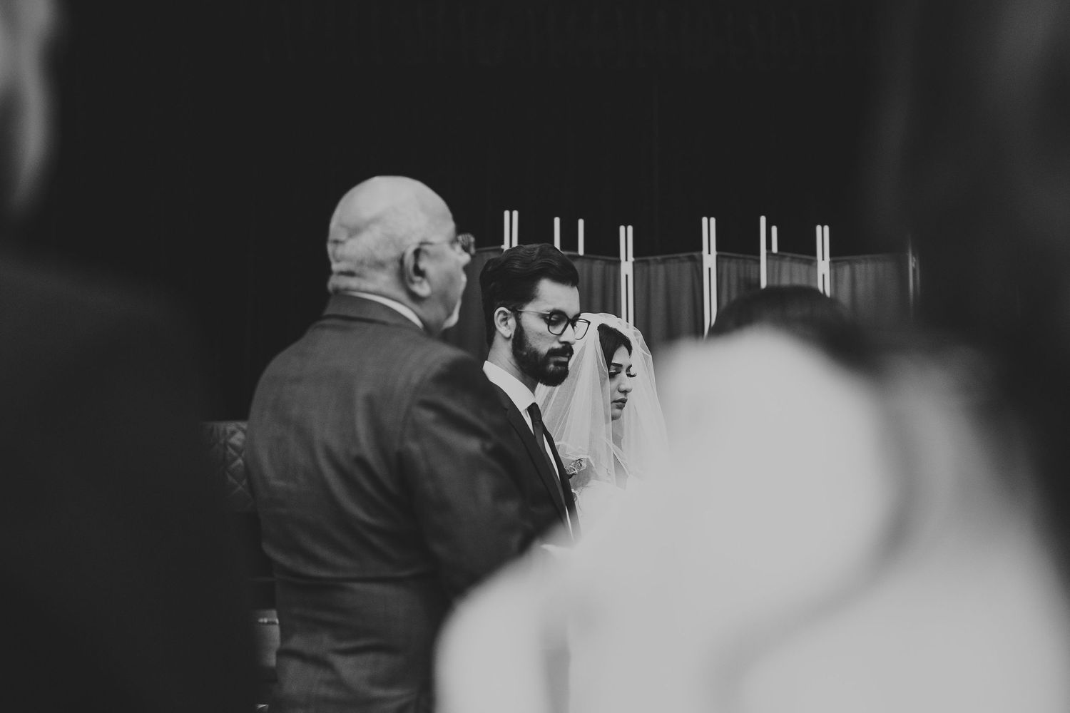 A black and white candid moment captured during a wedding ceremony.