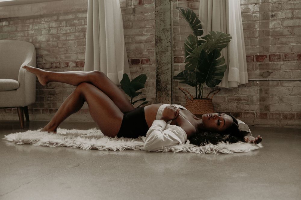 Contemporary fashion photography in industrial setting with natural lighting and minimalist styling.