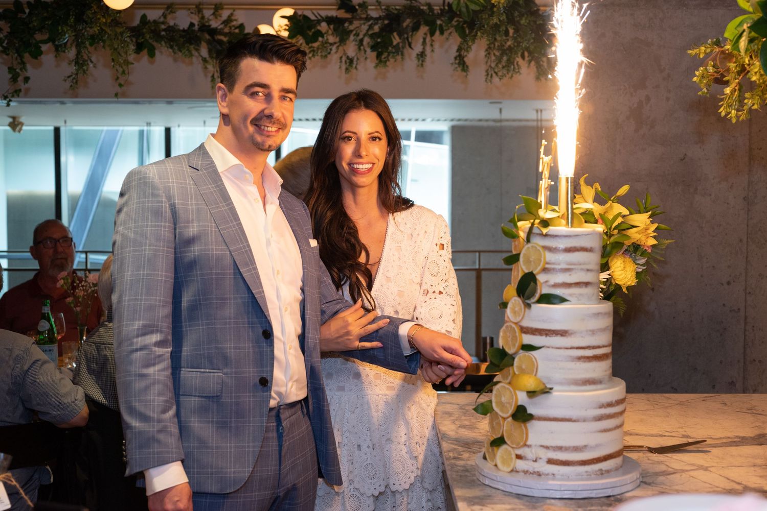A celebratory moment with a sparkler-topped wedding cake at a modern venue.