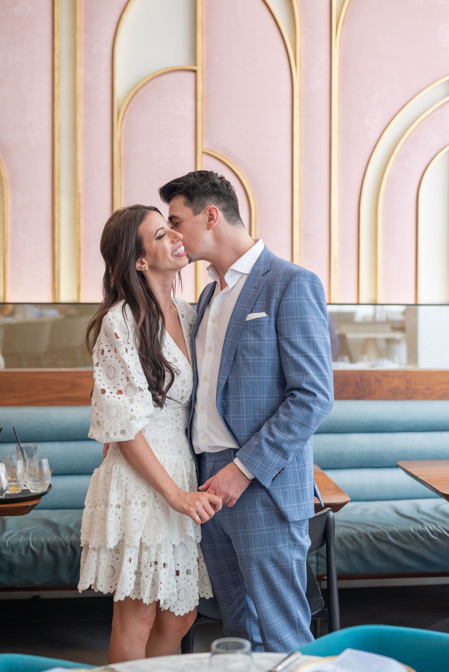 A romantic moment captured between a couple in an elegant restaurant setting.