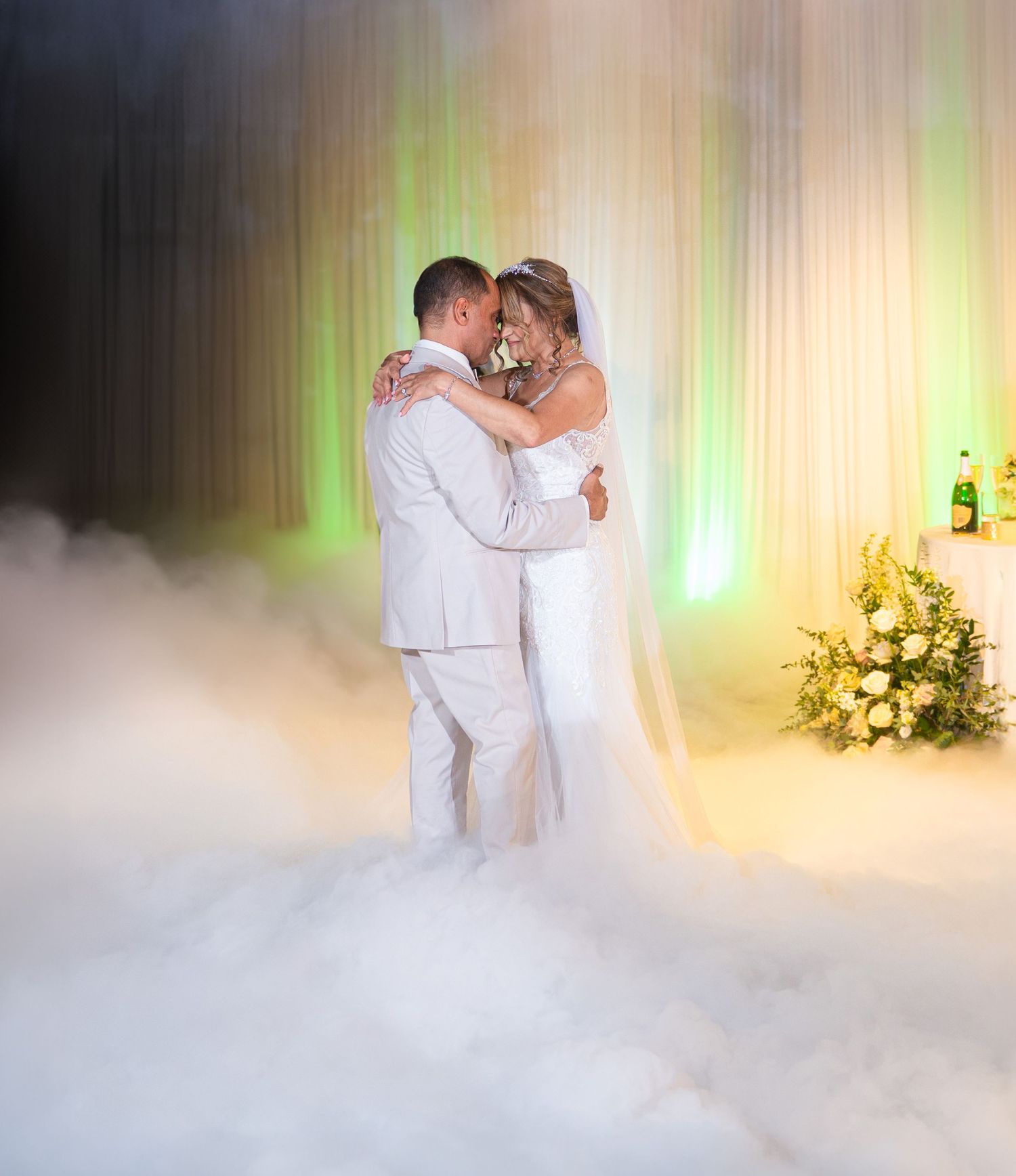A dreamy first dance moment with dry ice fog effect and elegant lighting at a wedding reception.