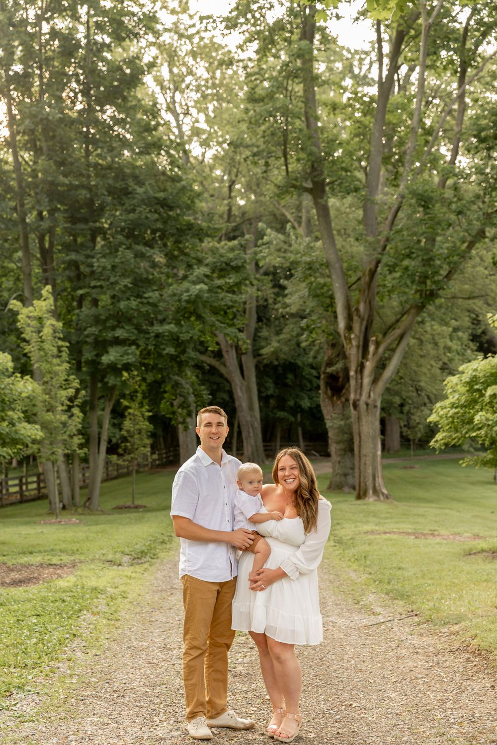 family of three wearing cream and khaki smiling for a photo at cranberry lake park