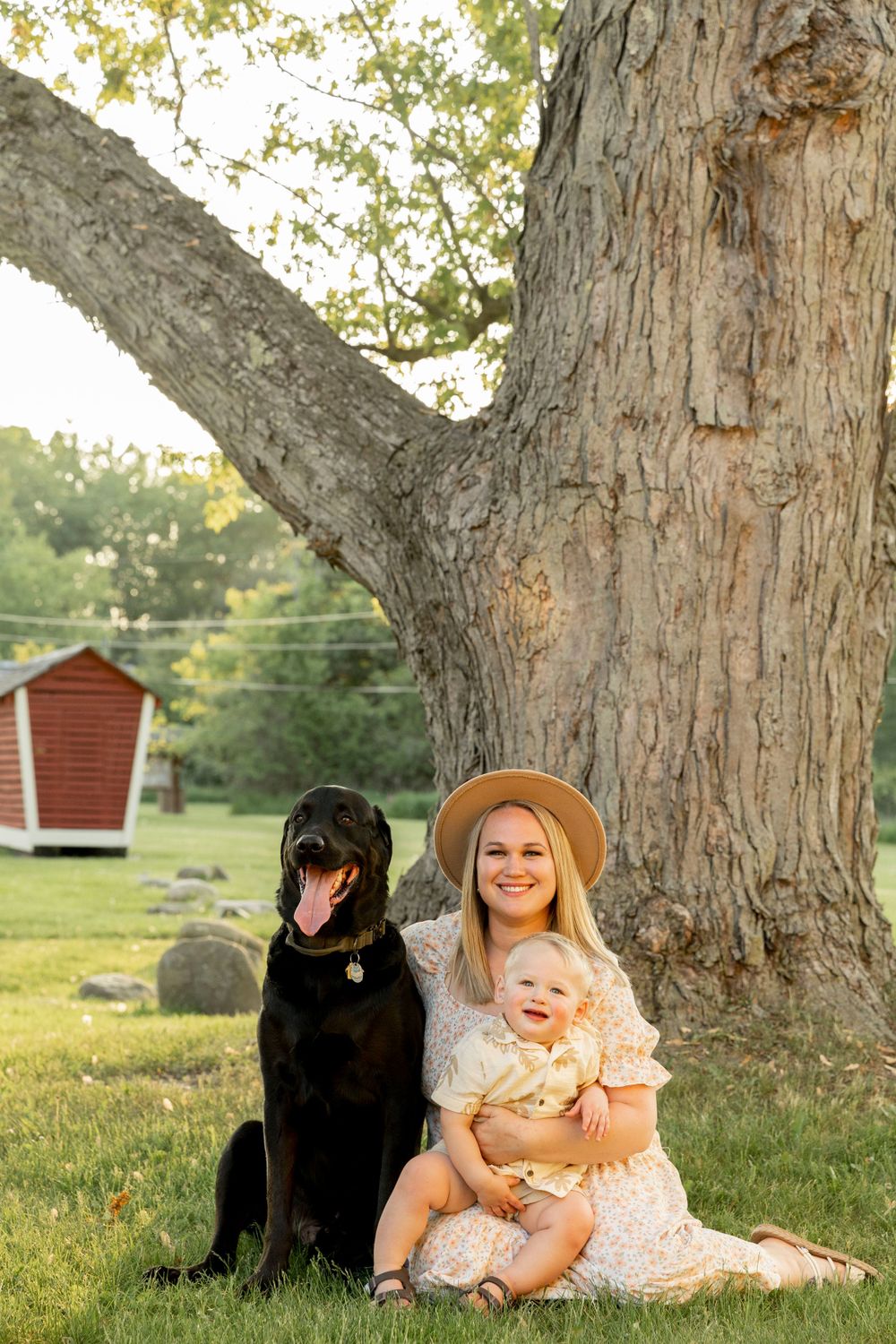 mother, son and dog smile for a photo on farmland
