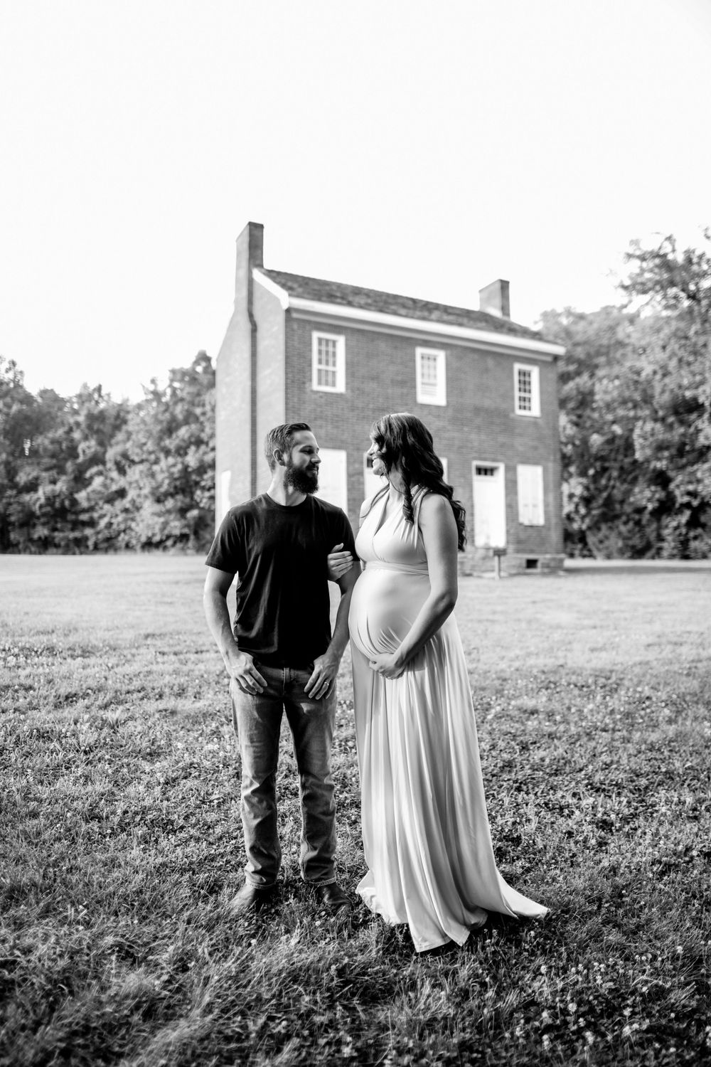 A black and white portrait session in front of a rustic brick building.