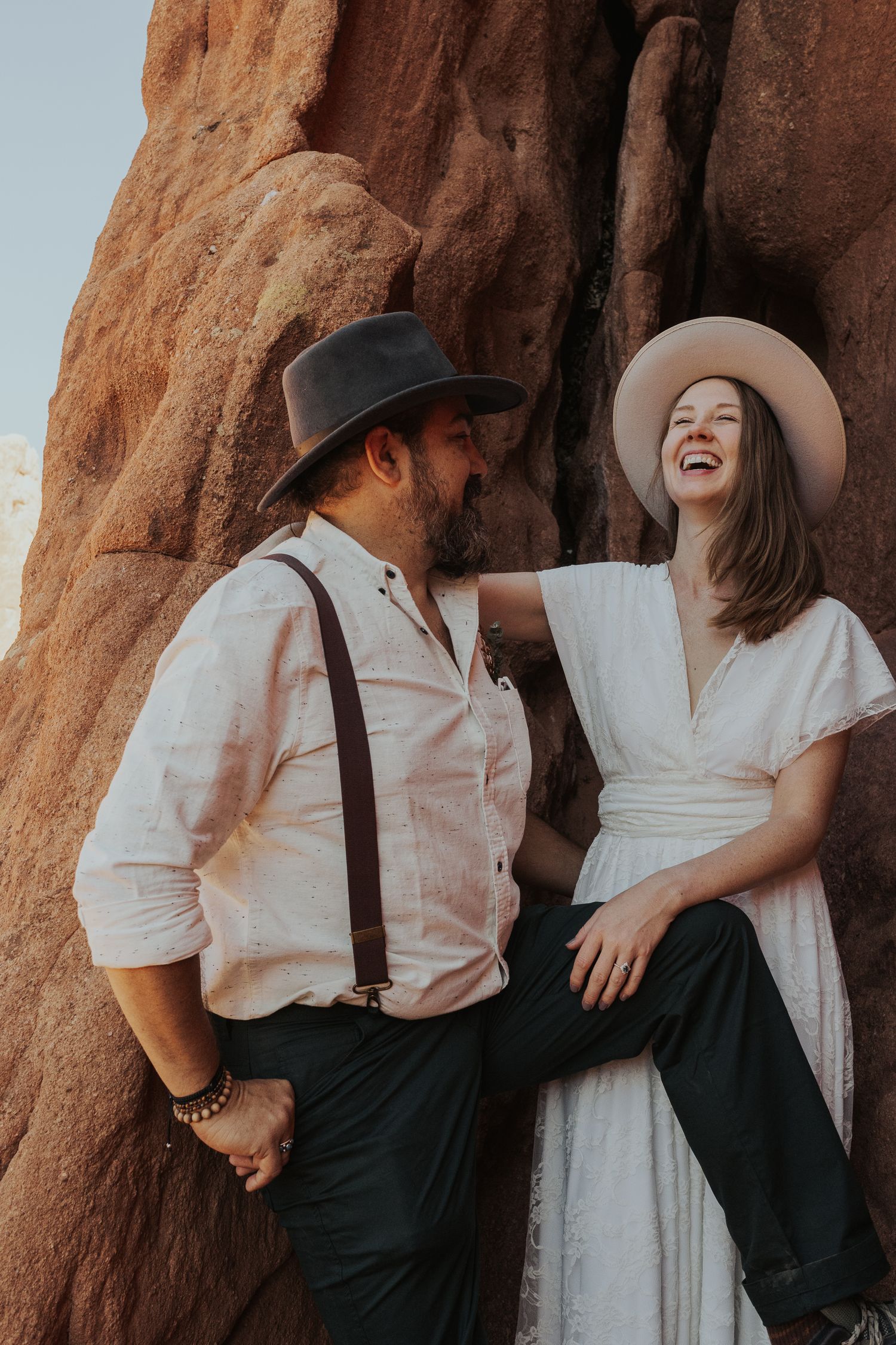 portraits after elopement ceremony; couple is nestled in the natural rock formations smiling