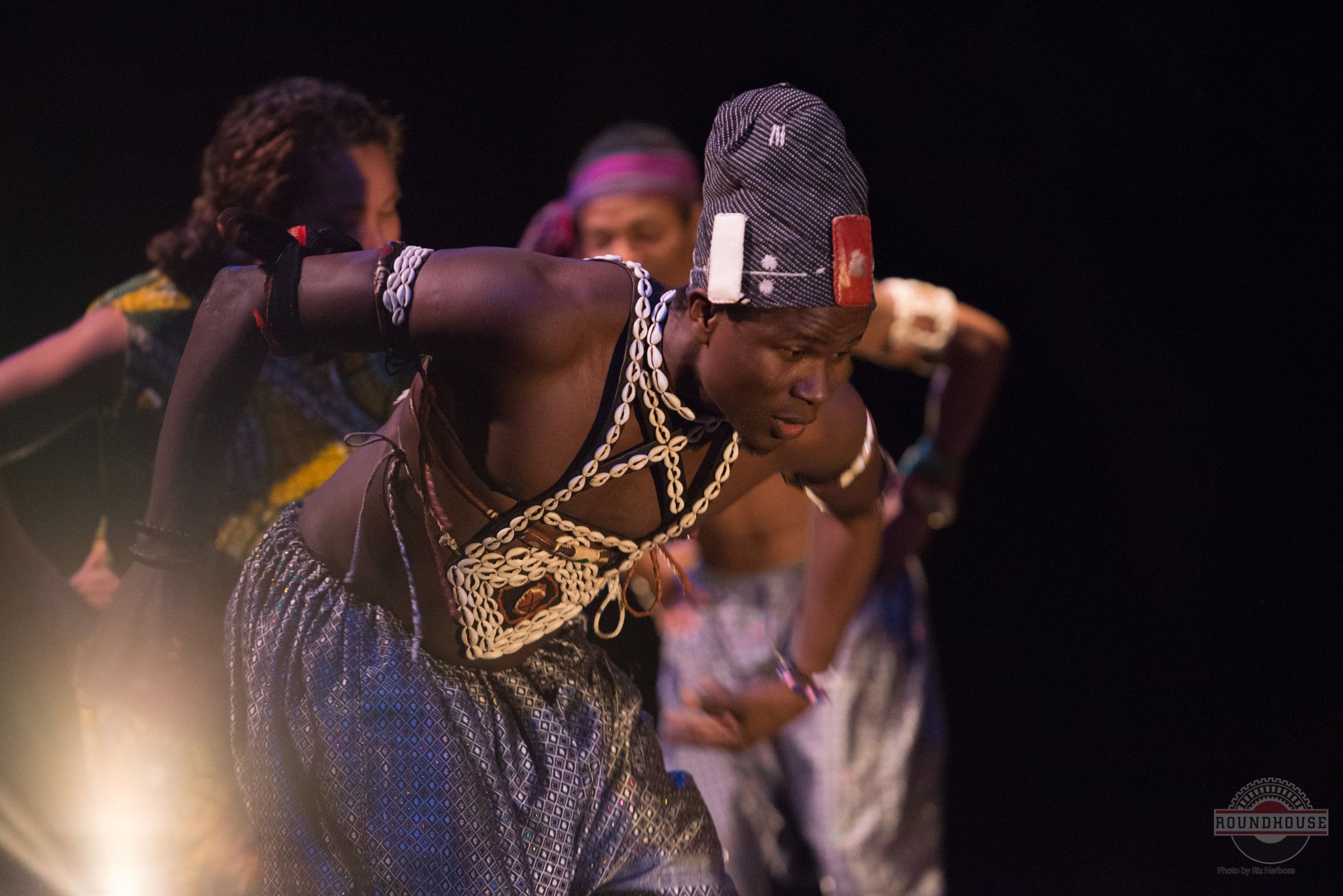 African Dancers perform an energetic movement sequence under dramatic stage lighting by one of Vancouver's best photographer, Riz Herbosa.