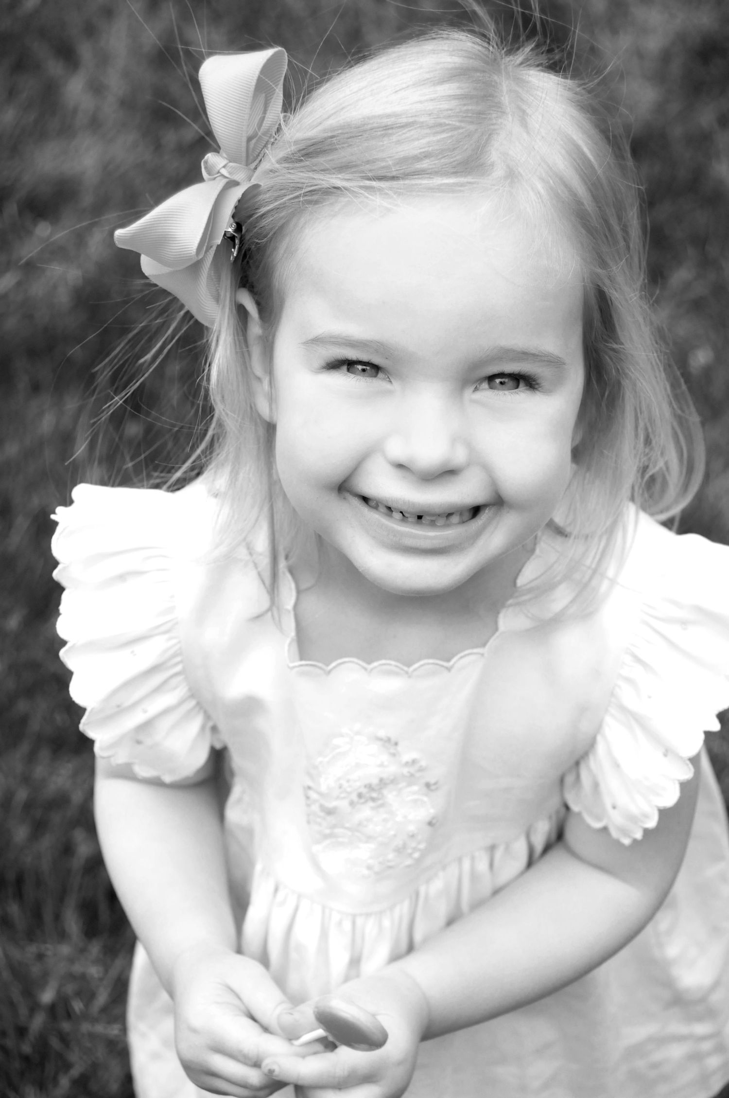 black and white photo of little girl smiling close up