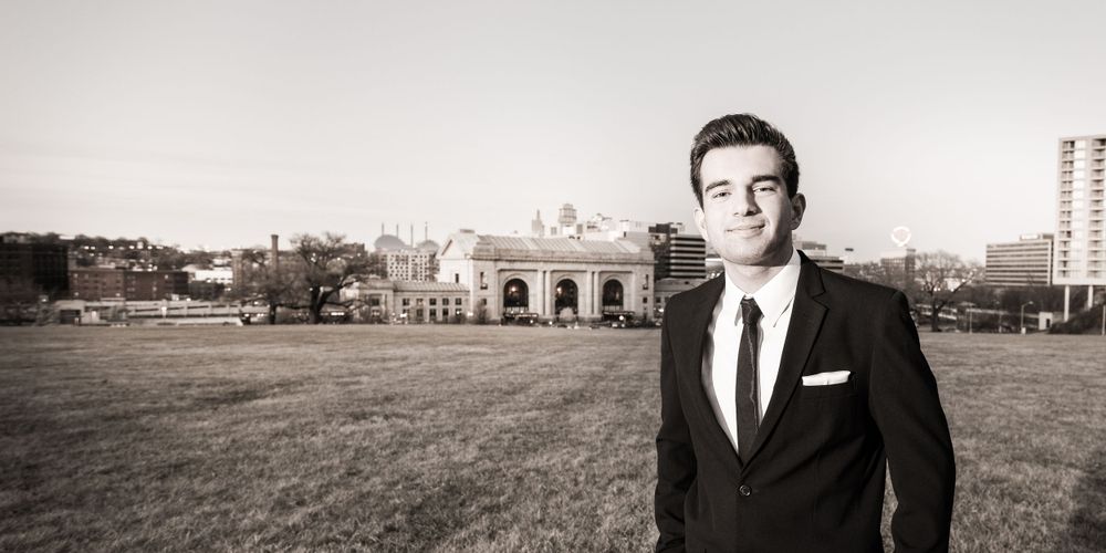 Formal portrait on grounds with historic building in background.